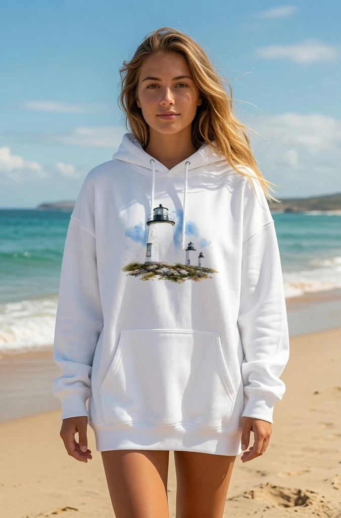 Woman wearing a white hoodie with a lighthouse design on a beach