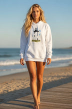 Woman wearing a white hoodie with a lighthouse design on a beach