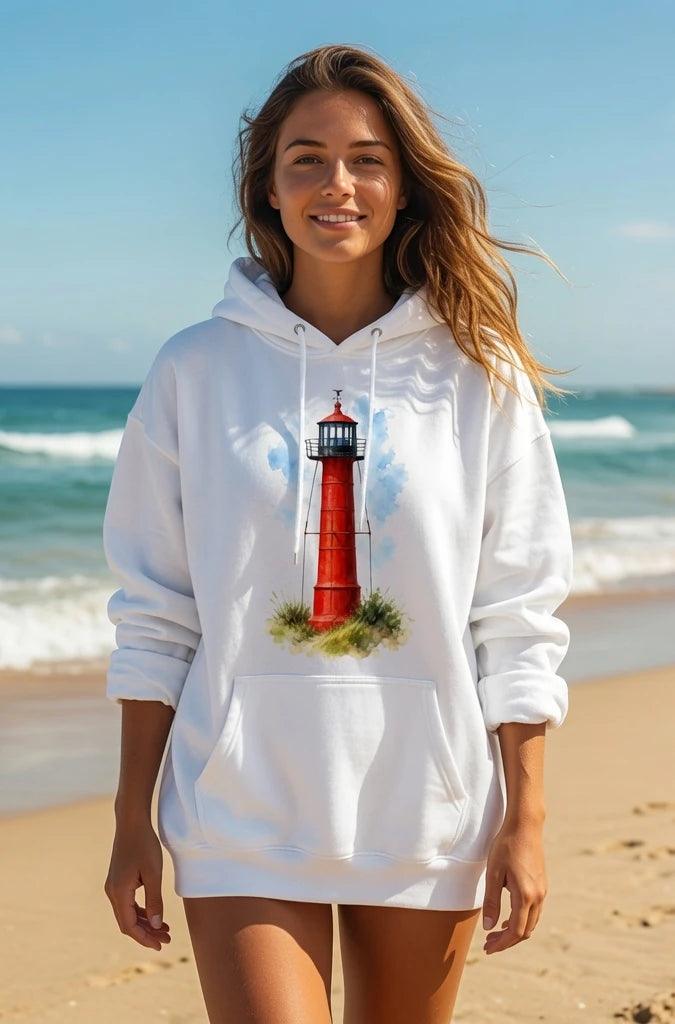 Woman wearing a white Cape Cod Lighthouses – Monomy Point Watercolor Coastal Hoodie with a lighthouse design on a beach