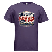 This County Has a Voice patriotic t-shirt design with bold red and blue vintage Americana lettering, American flag elements, rural county road, stars, and True American Candidate People First banner.